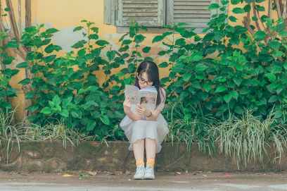 woman wearing white dress reading book